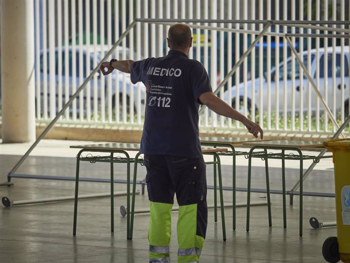 Un médico ordena las inmediaciones del Instituto de Educación Secundaria de Mendillorri la zona donde realizarán durante esta tarde pruebas PCR de diagnóstico de COVID-19 a jóvenes de entre 17 y 28 años, en Pamplona, Navarra (España), a 23 de julio de 2